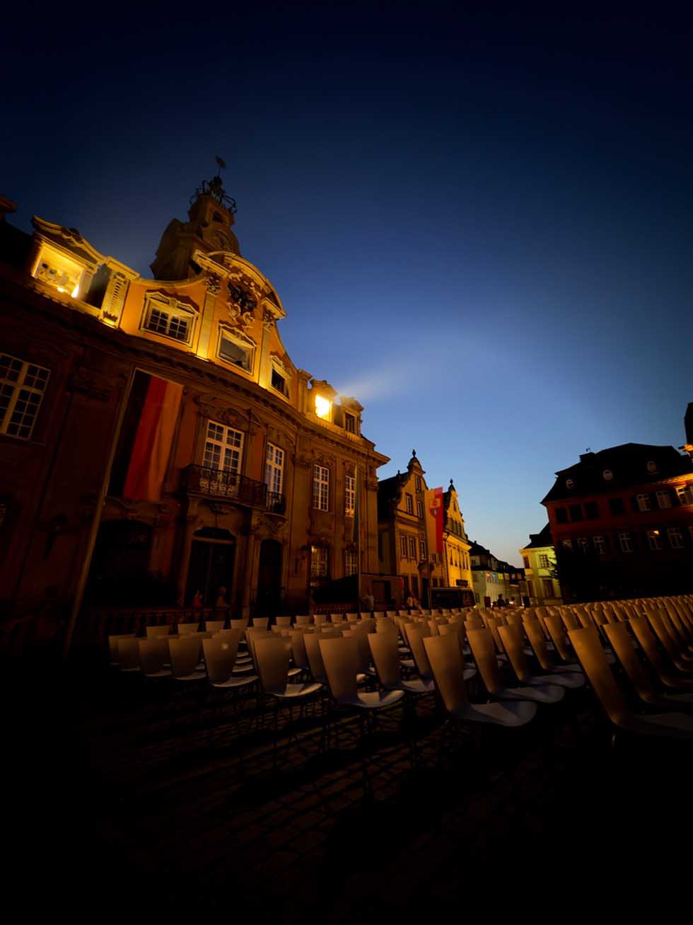 Rathaus in der Altstadt von Schwäbisch Hall bei Nacht mit stimmungsvoller Beleuchtung und besonderem Ambiente. Im Vordergrund befinden sich die Bestuhlung für die Freilichtspiele auf der Treppe.