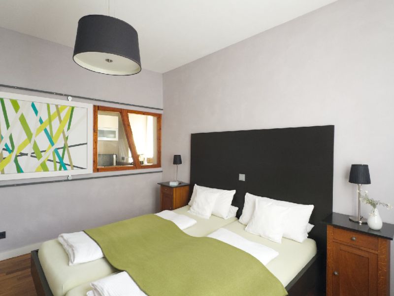 Gemütliches Schlafzimmer der Ferienwohnung mit Doppelbett, Dachschräge und dekorativen Akzenten im stilvollen Altbauambiente.