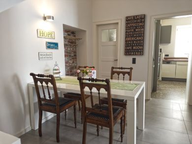 Blick in den Flur und Essbereich mit weißem Tisch und 4 Holzstühlen
