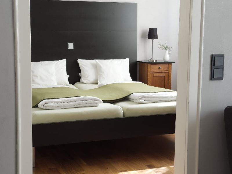 Ruhiges Schlafzimmer der Ferienwohnung mit großem Doppelbett, hochwertiger Bettwäsche und stilvoller Einrichtung zum Wohlfühlen.