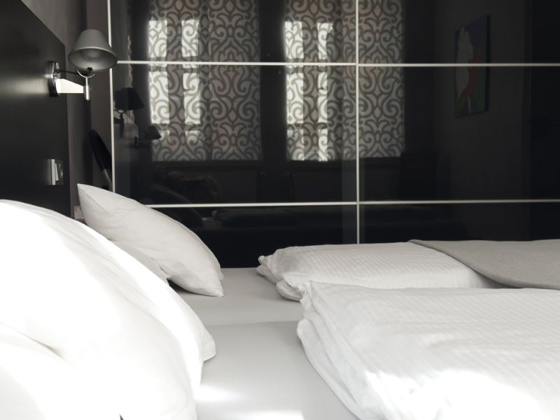 Detailaufnahme von Schlafzimmer 2 der Ferienwohnung mit bequemen Betten, großem Kleiderschrank und stilvoller Einrichtung für erholsame Nächte.